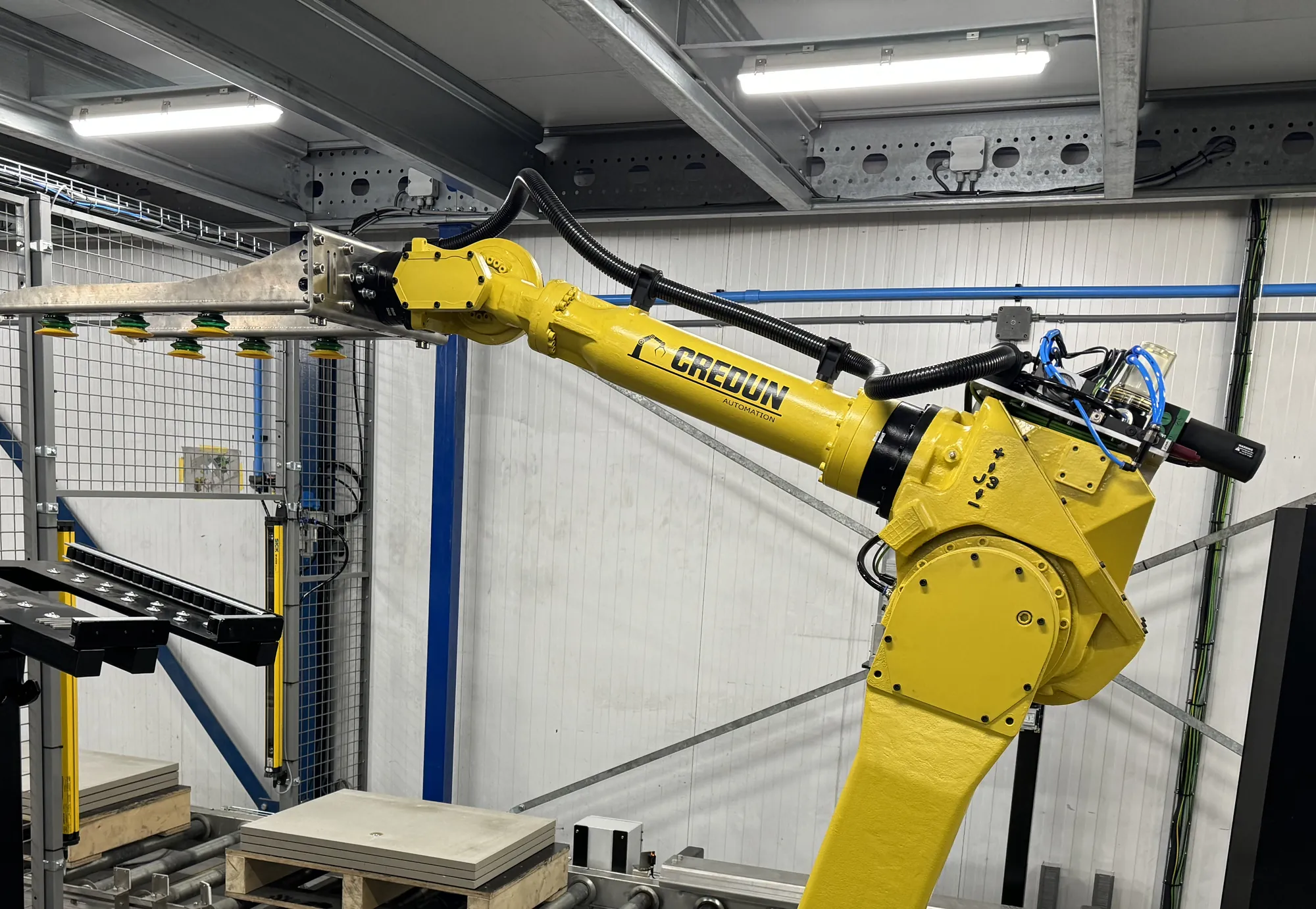 Yellow robot with the black Reiku protective hose along the arm