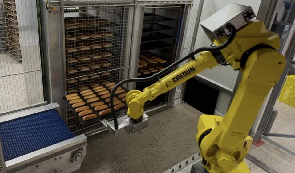 Robot with protective hose in a bakery line