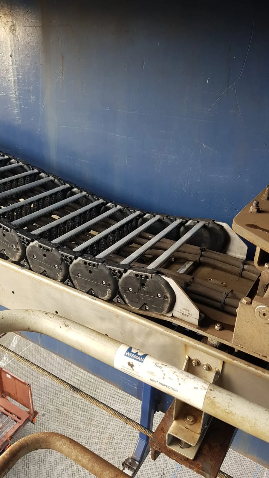 End bracket of the cable carrier with Wisman inspection sticker