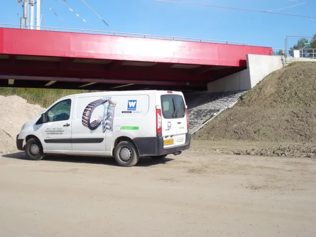 De bus van Wisman Techniek onder de brug