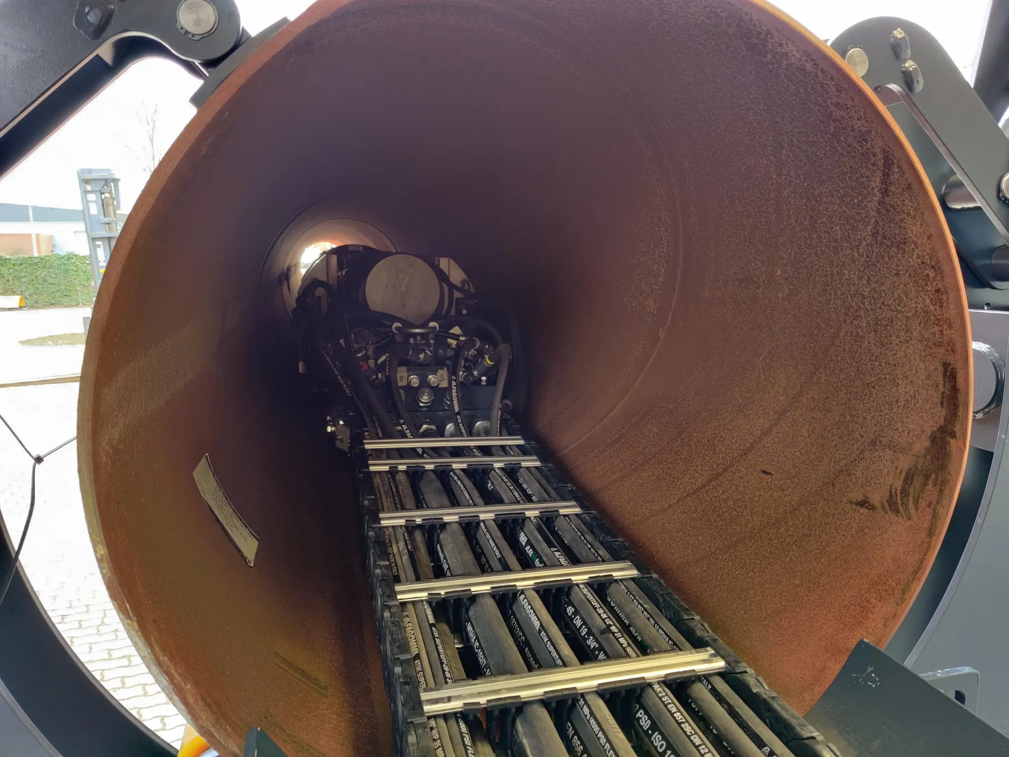 Cable carrier with hydraulic hoses in the tube, on its way to the welding machine