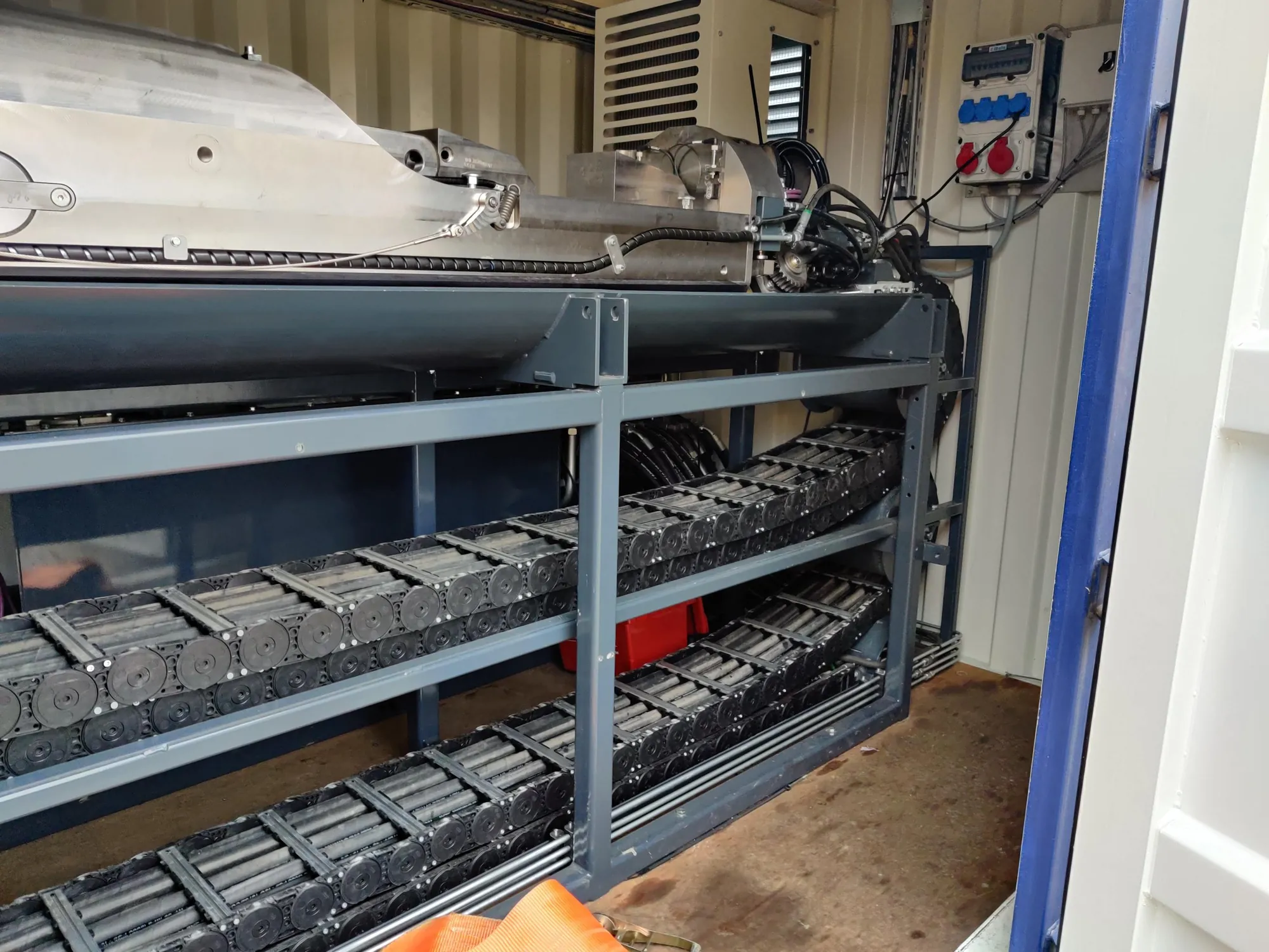 Stacked cable carriers under the machine in the container