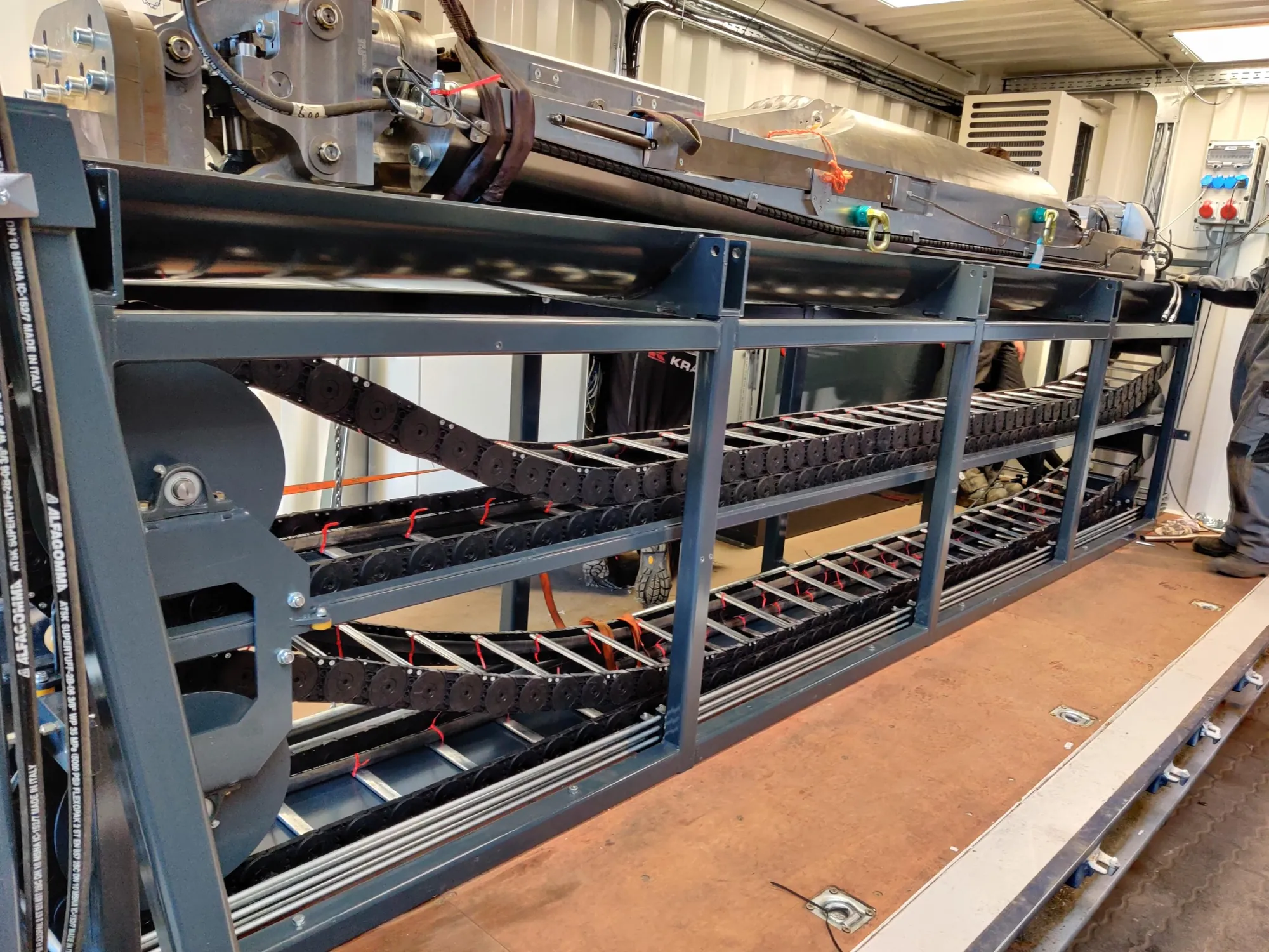 The frame with the cable carriers along the length of the container