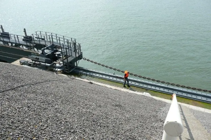 Monteur entlang der Führung der Energiekette