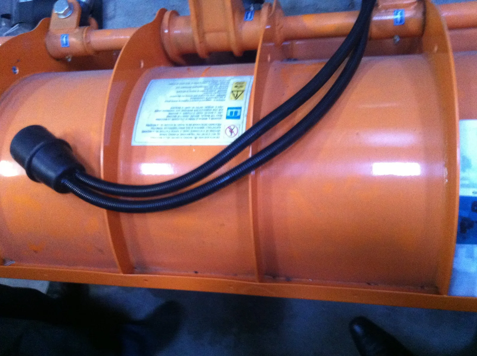 Protective hoses on an orange Okkerman snow plough