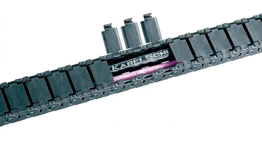 Dark grey cable carrier with an open section, showing a pink cable and the text "KABELSCHLEPP" inside